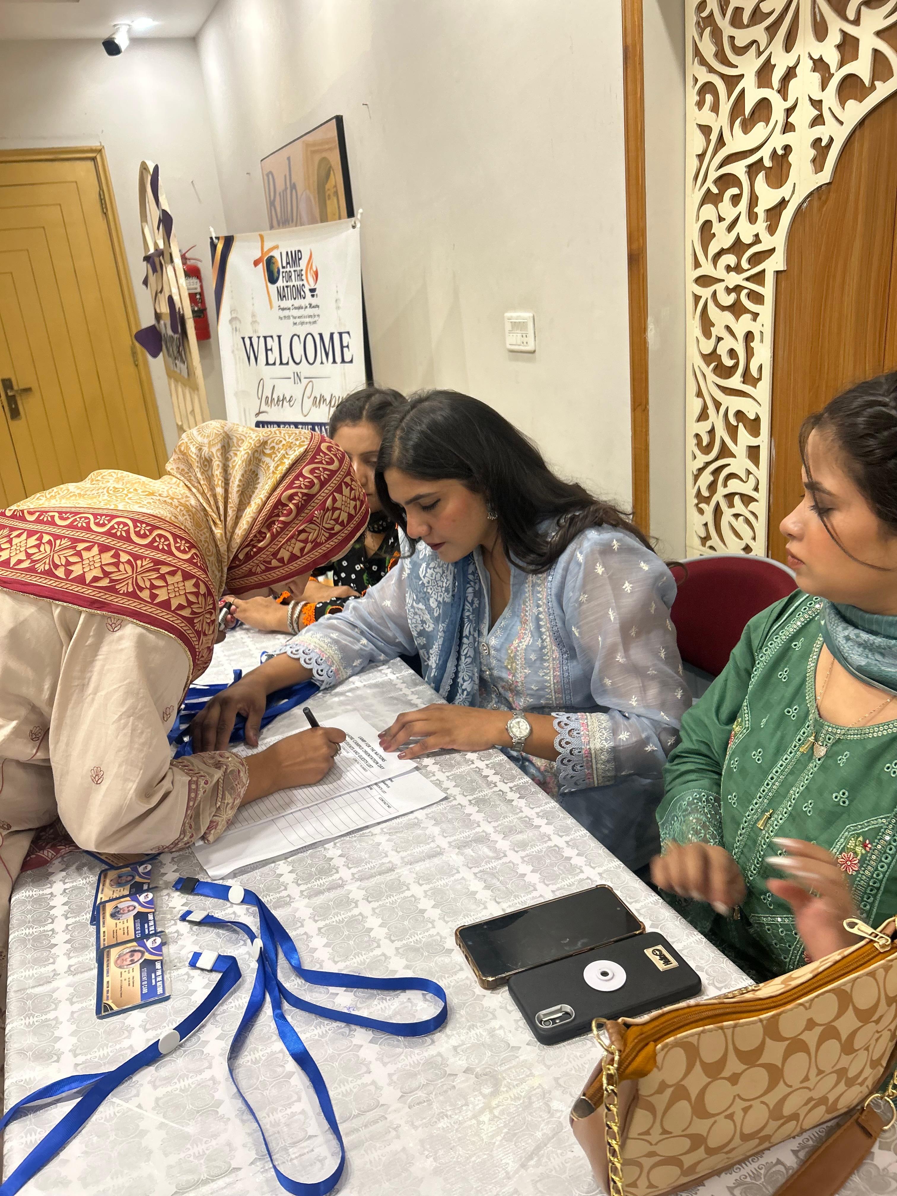 A student signing in at the Lahore Campus orientation registration table